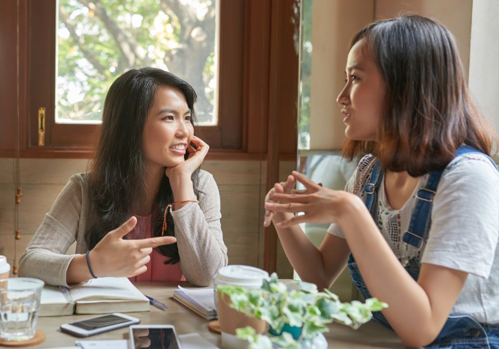 Two women engaged in conversation at a cafe table